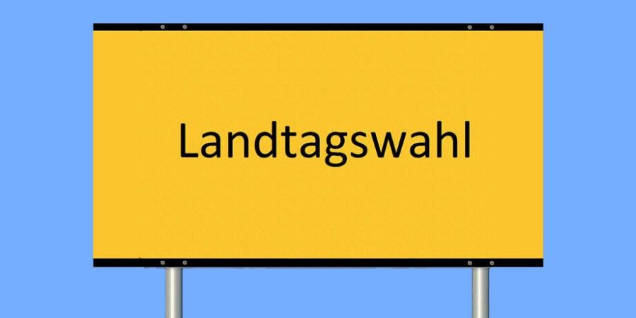 Schild auf zwei Stangen in Form eines Ortsschildes, mit Beschriftung "Landtagswahl"