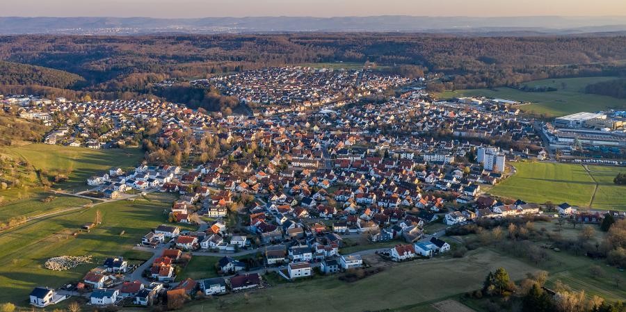 Dettenhausen, inmitten des Naturparks Schönbuch Große Ortschaft, eingebettet in Kulturlandschaft, im Hintergrund Wald und Berge