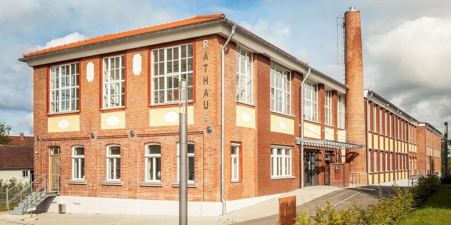 Rathaus Gomaringen Zweistöckiges ehemaliges Fabrikgebäude aus Ziegeln, mit Schornstein an der Längsseite, Beschriftung "Rathaus".