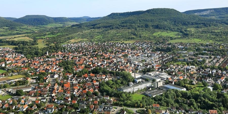 Mössingen Luftbild der Stadt mit Häusern, im Hintergrund Berge der schwäbischen Alb