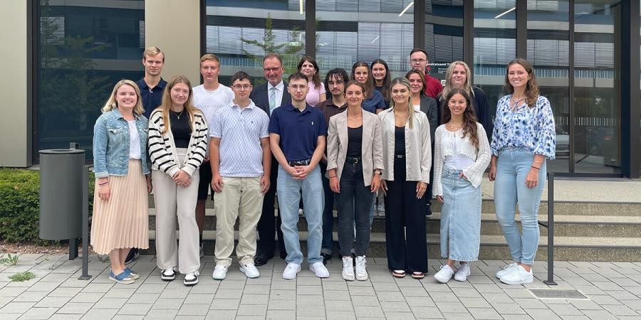 Gruppe von jungen Leuten, mit Landrat Walter vor einem Gebäude des Landratsamts