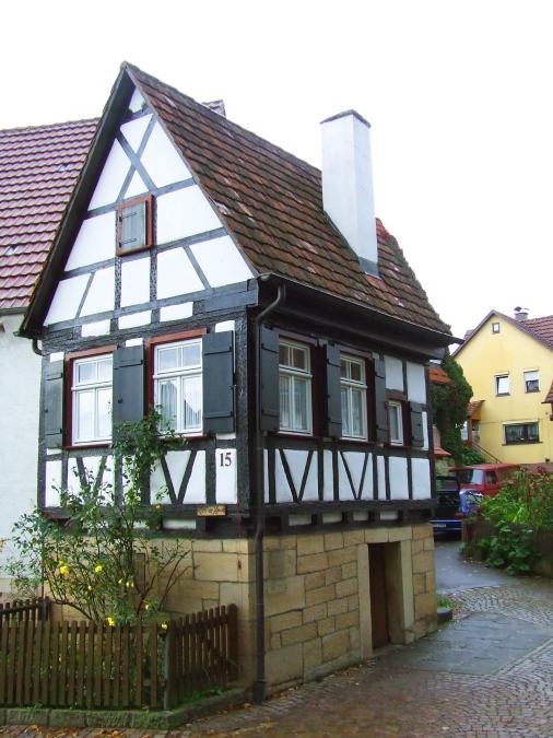 Kleines Fachwerkhaus mit Satteldach auf Steinsockel mit kleinem Vorgarten