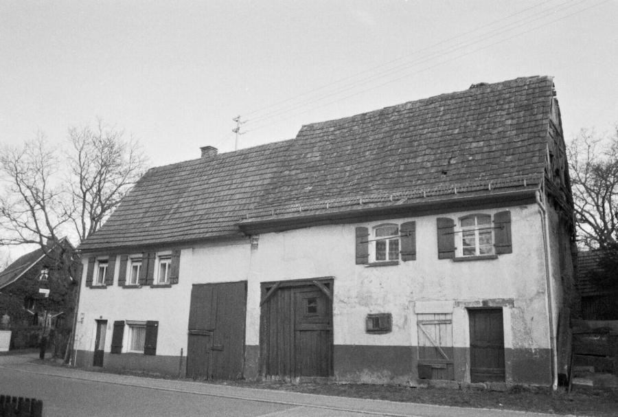 Zwei aneinandergebaute Häuser mit Scheunentoren und Stalltür