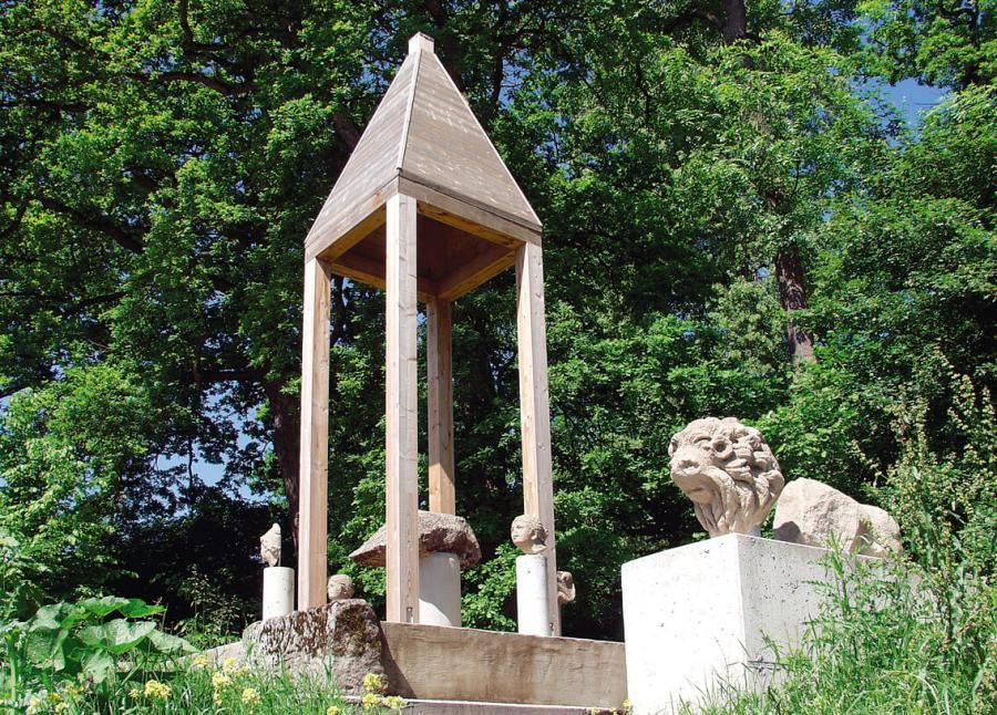 Ausstellung im Freien von Steinskulpturen, unter anderem Fragmente wie das aus Stein gehauene Schindeldach des früheren Grabmals, eine Sphinx, Menschenköpfe, ein hölzerner Aufbau wurde für das Denkmal errichtet, das auf vier Säulen stehende Pyramidendach erinnert an das Pfeilergrab)
