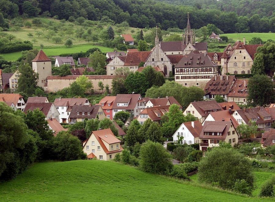 Kloster Bebenhausen mit Klosterkirche und spätgotischem Dachreiter, Klostergebäuden und Mauer, Häuser des Orts Bebenhausen, umgeben von Wiesen teils mit Streuobstbäumen und Wald