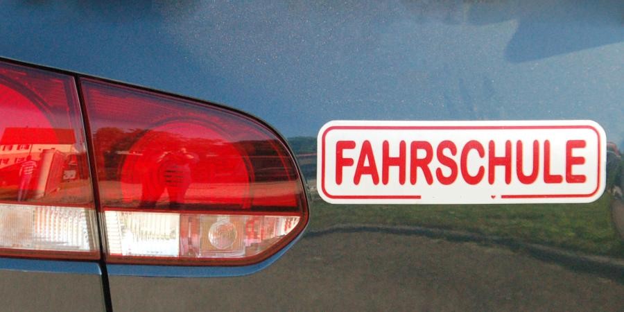 Teil eines Autohecks, neben dem Rücklicht ein Aufkleber "FAHRSCHULE"
