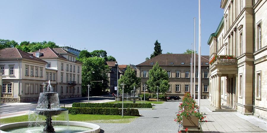 Teil des klassizistischen Universitätsgebäudes mit Vorplatz und Springbrunnen, umgebende Bebauung aus dem 19. Jahrhundert