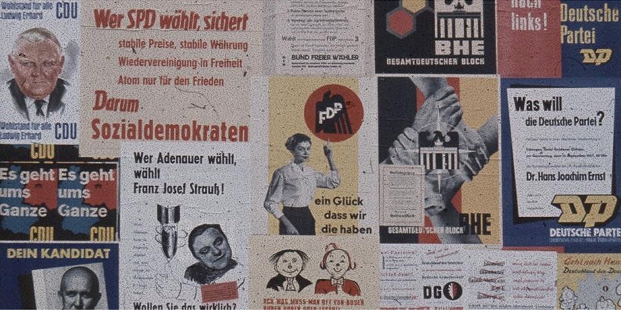 Ausschnitt einer Plakatwand mit Wahlplakaten mehrerer Parteien von 1957