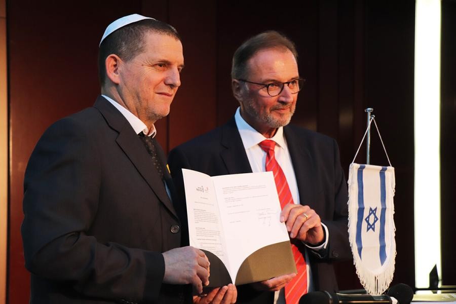 Zwei Personen halten gemeinsam eine Urkunde