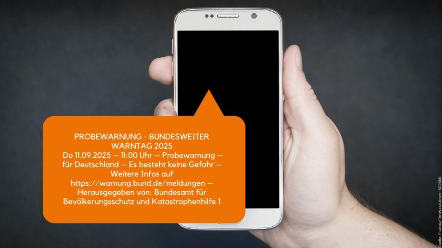 eine Hand hält ein Smartphone, als Sprechblase dargestellt ist ein Text "Probewarnung - Bundesweiter Warntag 2025" mit weiteren Informationen