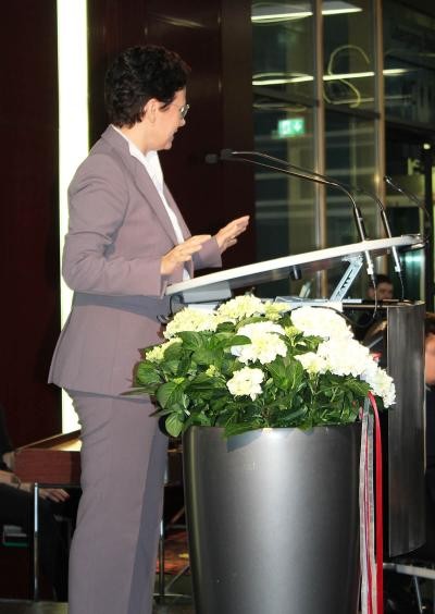 Ministerin Marion Gentges am Rednerpult, daneben eine große Blumenvase