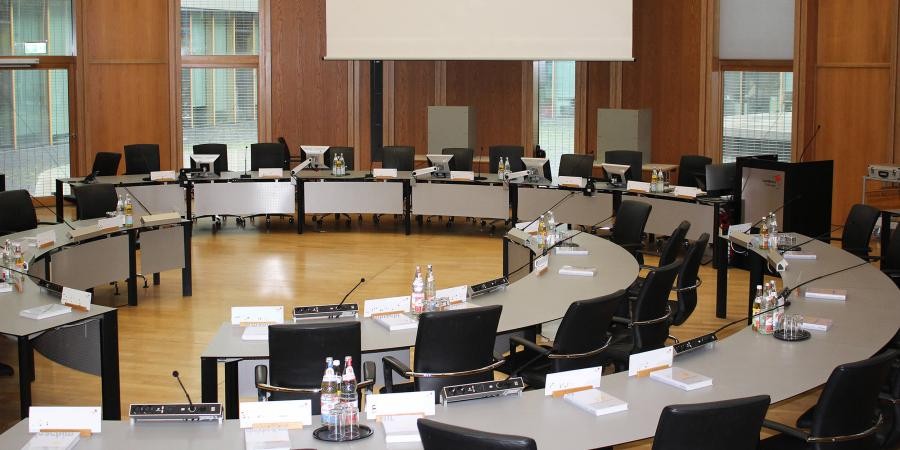 Blick in den Sitzungssaal im Landratsamt, im Kreis aufgestellte Tischreihen 
