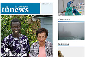 Titel des Online-Magazins TüNews international, Titelbild eines jüngeren Mannes mit schwarzer Hautfarbe und einer älteren Frau mit weißer Hautfarbe, weitere Bilder von einem medizinischen Behandlungsraum mit Spritze, einer Landschaft im Nebel, Überschriften TüNews World, TüNews Local.