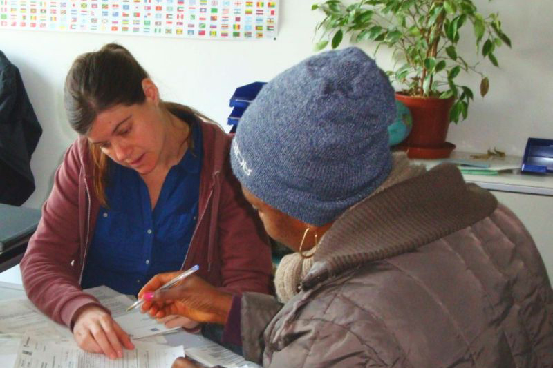 Zwei Personen sitzen an einem Tisch und bearbeiten gemeinsam ein Formular