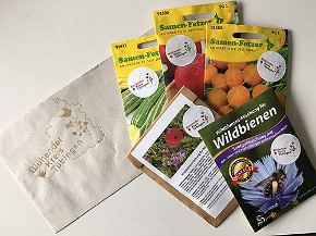 Ein Briefumschlag mit aufgedrucktem Logo "Blühender Kreis Tübingen" und fünf verschiedene Samentüten mit dem Aktionsaufkleber