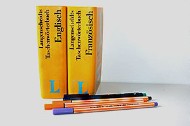 Zwei Sprachwörterbücher "Englisch", "Französisch", davor liegen Stifte