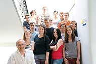 Eine Gruppe von etwa zwanzig Personen hat sich für das Gruppenfoto auf einer Treppe aufgestellt